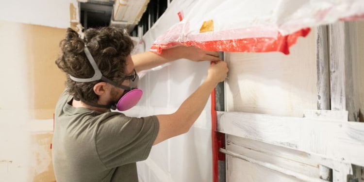 Blog_Header_Manworkingonwall