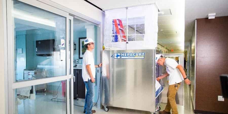2 men using a HEPACART Auto Lift in a hallway