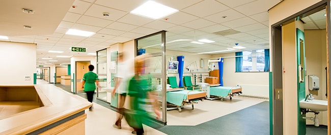 A busy healthcare facility, with sectioned off patient care areas for environmental infection control purposes.