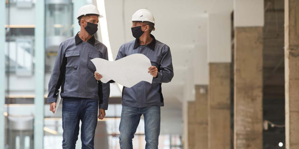 Two workers going over blueprints