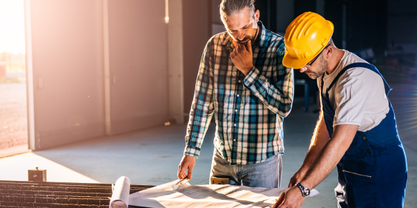 Two construction workers looking at blueprints