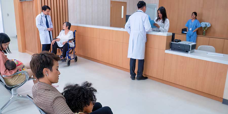 Patients and staff in an ambulatory surgery center waiting room with clinical team at reception desk