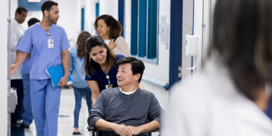 Nurse rolling a man in a wheelchair